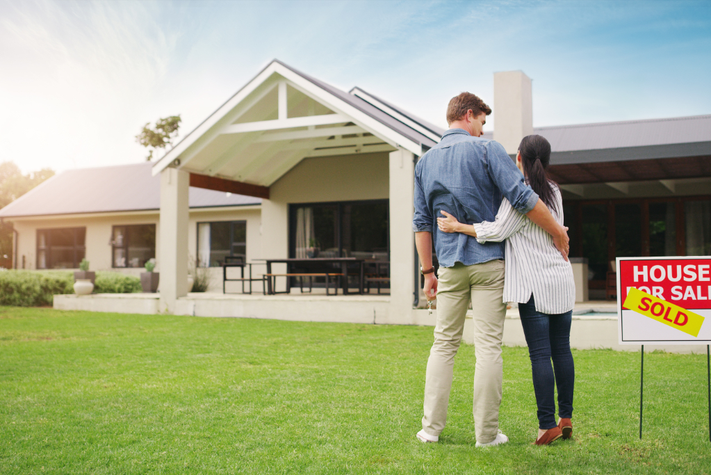 Shot of a young couple admiring their newly purchased house